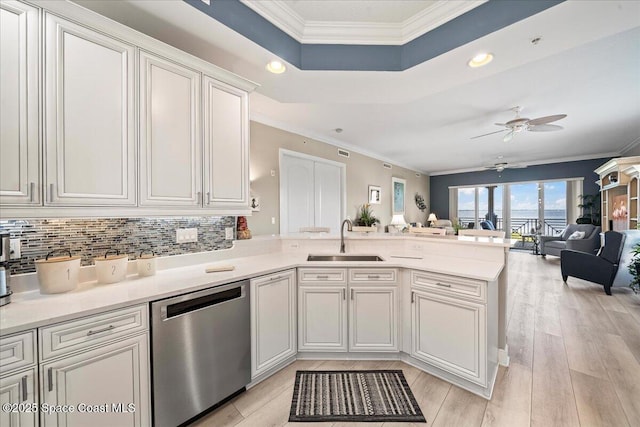 kitchen with stainless steel dishwasher, a sink, crown molding, a peninsula, and ceiling fan
