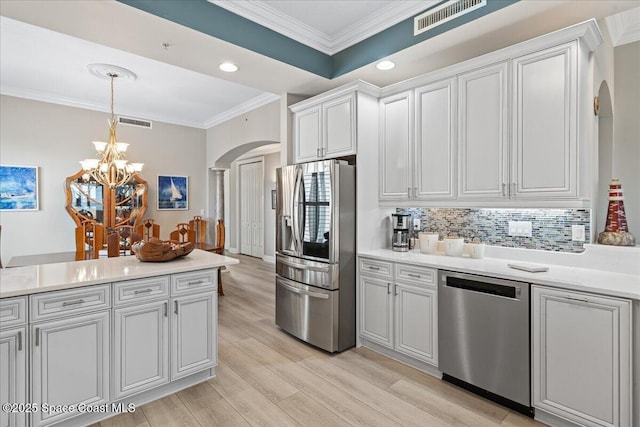 kitchen with arched walkways, visible vents, a notable chandelier, crown molding, and appliances with stainless steel finishes