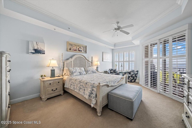 bedroom with light colored carpet, access to exterior, ornamental molding, and a tray ceiling
