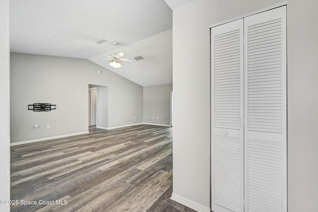 interior space with wood finished floors, ceiling fan, baseboards, and a textured ceiling