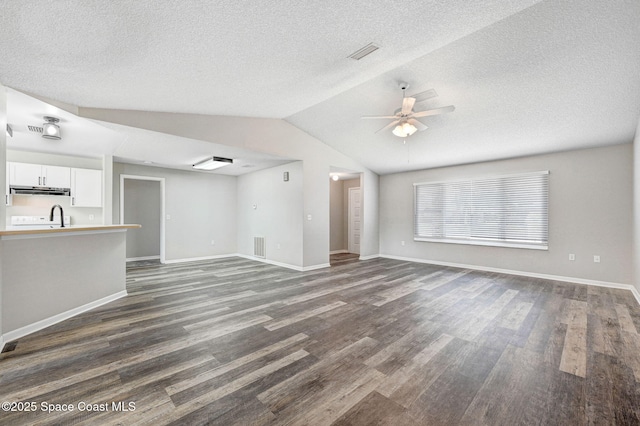 unfurnished living room featuring a sink, baseboards, vaulted ceiling, dark wood finished floors, and a ceiling fan