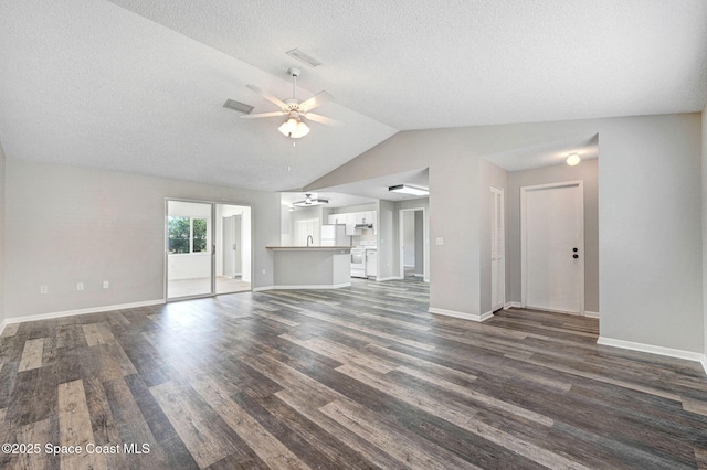 unfurnished living room with vaulted ceiling, ceiling fan, baseboards, a textured ceiling, and dark wood-type flooring