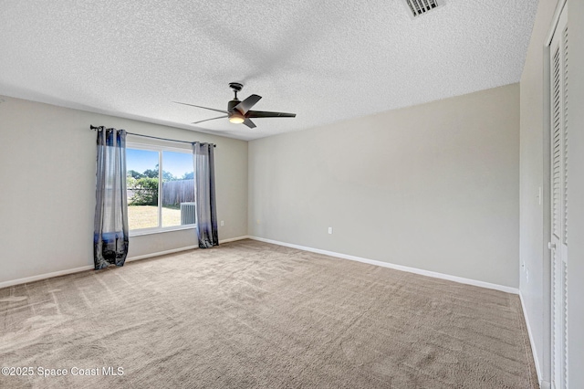 carpeted spare room featuring a textured ceiling, visible vents, ceiling fan, and baseboards