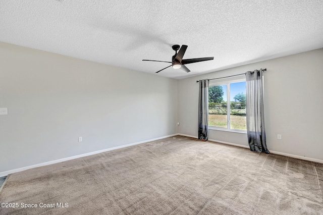 carpeted spare room featuring a ceiling fan, a textured ceiling, and baseboards