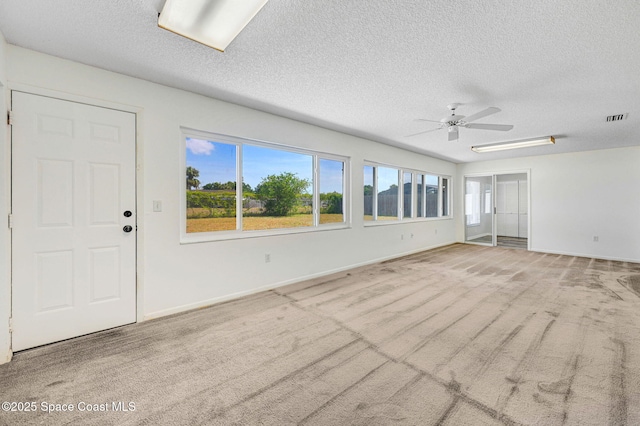 unfurnished living room featuring carpet, visible vents, and a textured ceiling