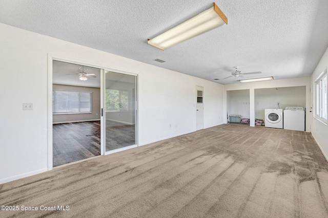 unfurnished living room featuring independent washer and dryer, carpet, ceiling fan, visible vents, and a textured ceiling