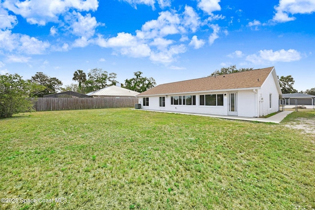 rear view of property with fence, stucco siding, and a yard