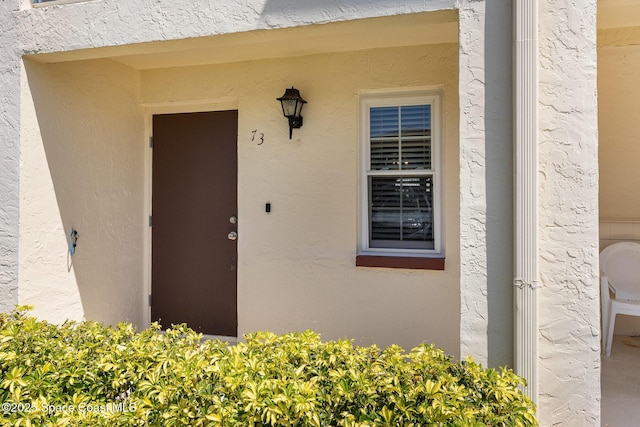 property entrance with stucco siding