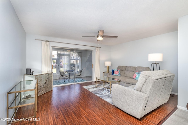 living room with wood finished floors, baseboards, and ceiling fan