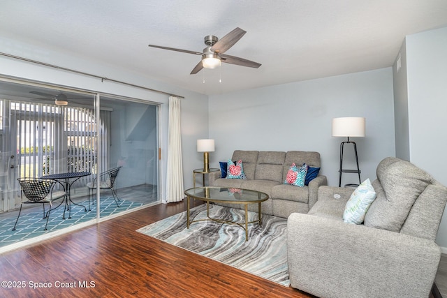 living area with wood finished floors and ceiling fan