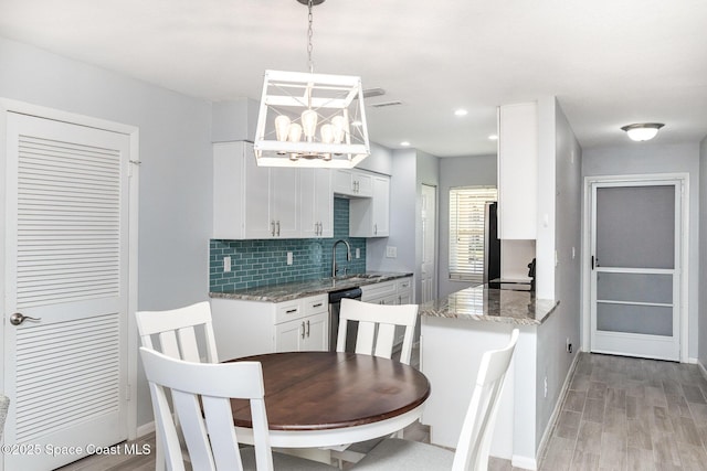 dining space with baseboards, an inviting chandelier, and light wood-style flooring