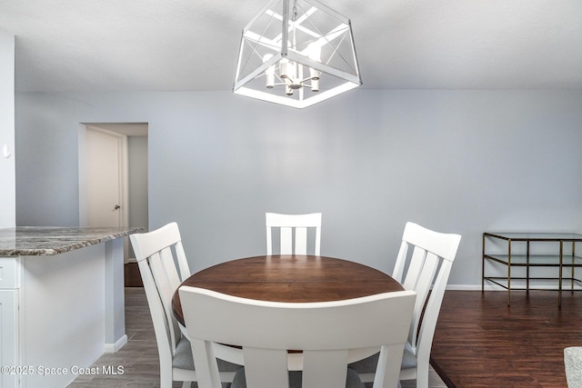 dining room with a chandelier, wood finished floors, and baseboards