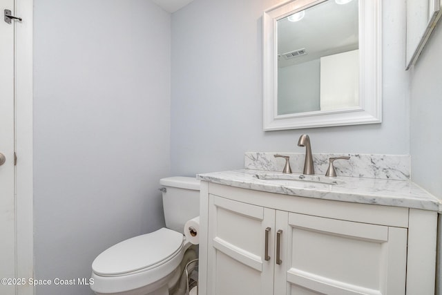 bathroom featuring visible vents, vanity, and toilet