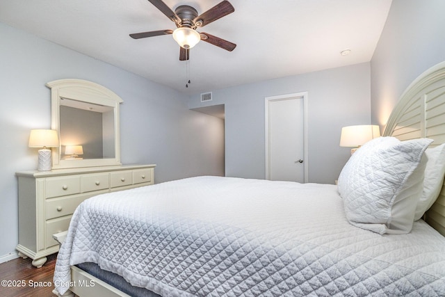 bedroom featuring dark wood-style floors, baseboards, a ceiling fan, and visible vents