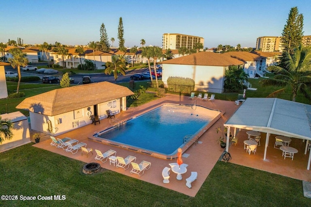 pool featuring a yard, a patio area, and fence