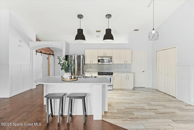 194 Saybrook Rd SW, Palm Bay, FL 32908 - kitchen featuring tasteful backsplash, a barn door, a decorative wall, light countertops, and appliances with stainless steel finishes