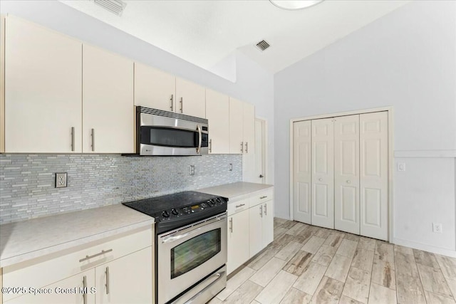 194 Saybrook Rd SW, Palm Bay, FL 32908 - kitchen with decorative backsplash, appliances with stainless steel finishes, visible vents, and light countertops