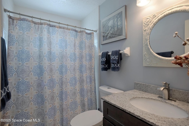 bathroom featuring a textured ceiling, toilet, and vanity