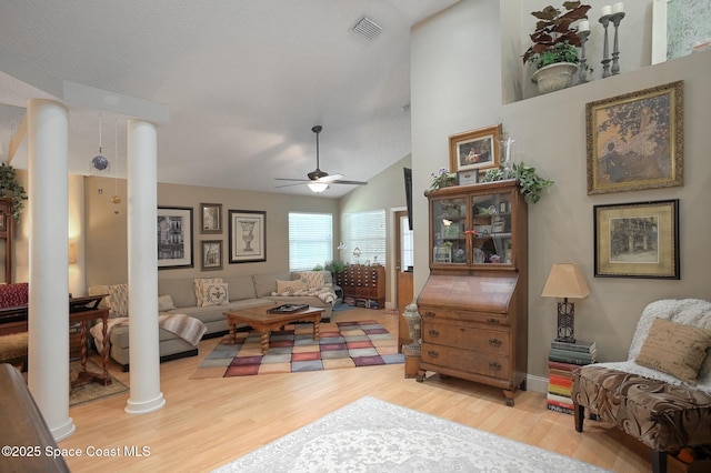 living room with wood finished floors, visible vents, ornate columns, and ceiling fan