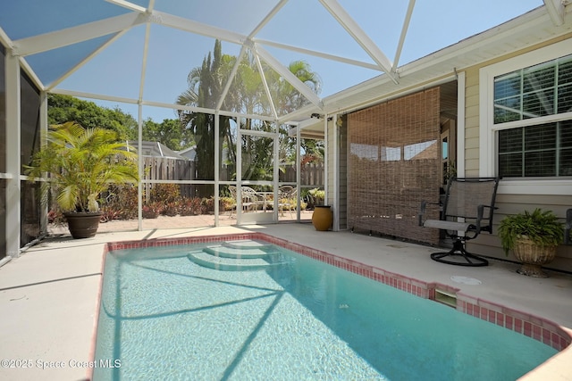 view of swimming pool with fence, a patio area, glass enclosure, and a fenced in pool