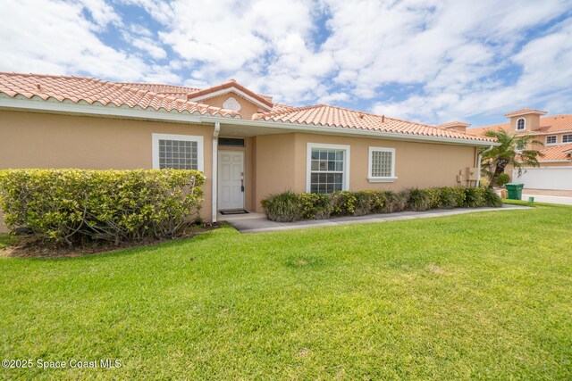 1298 Etruscan Way Unit 119, Indian Harbour Beach, FL 32937 - mediterranean / spanish-style house with a front yard, stucco siding, and a tiled roof