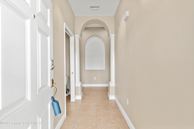 1298 Etruscan Way Unit 119, Indian Harbour Beach, FL 32937 - corridor with decorative columns, arched walkways, light tile patterned flooring, and baseboards