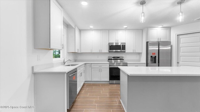 kitchen featuring white cabinets, stainless steel appliances, light countertops, wood finished floors, and a sink