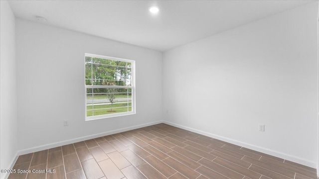spare room featuring baseboards, wood tiled floor, and recessed lighting