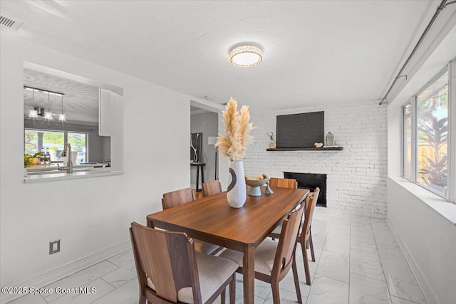 417 E Grant St, Orlando, FL 32806 - dining space with marble look tile flooring, a fireplace, and baseboards