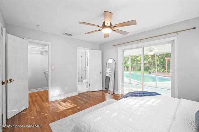 417 E Grant St, Orlando, FL 32806 - bedroom with access to outside, baseboards, a walk in closet, wood finished floors, and connected bathroom