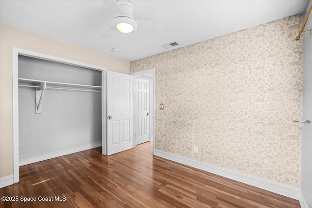 417 E Grant St, Orlando, FL 32806 - unfurnished bedroom featuring wallpapered walls, wood finished floors, a closet, and baseboards