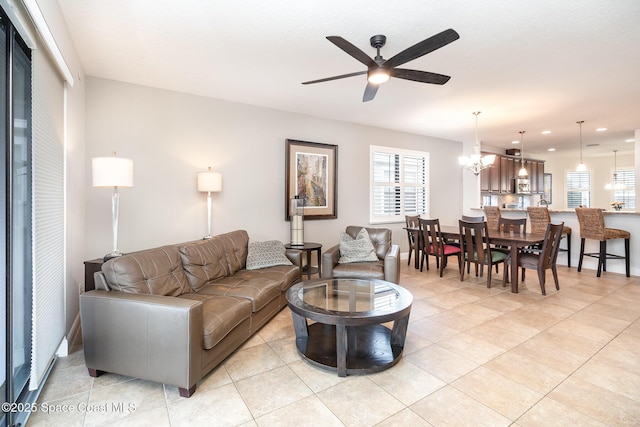 living room featuring ceiling fan with notable chandelier, recessed lighting, and light tile patterned floors