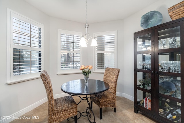 dining space featuring a chandelier, baseboards, and light tile patterned floors