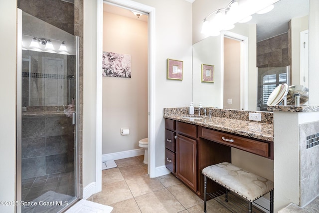 bathroom featuring a shower stall, tile patterned flooring, toilet, vanity, and baseboards