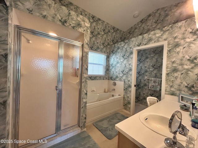 bathroom featuring a bath, vanity, wallpapered walls, and a stall shower