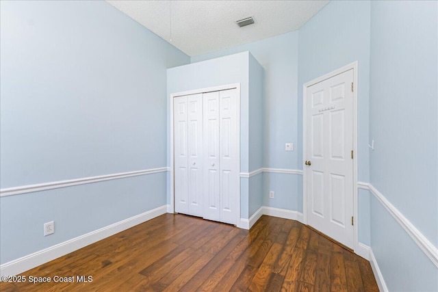 7016 Hammock Trace Dr, Melbourne, FL 32940 - unfurnished bedroom with dark wood-style flooring, a closet, and baseboards
