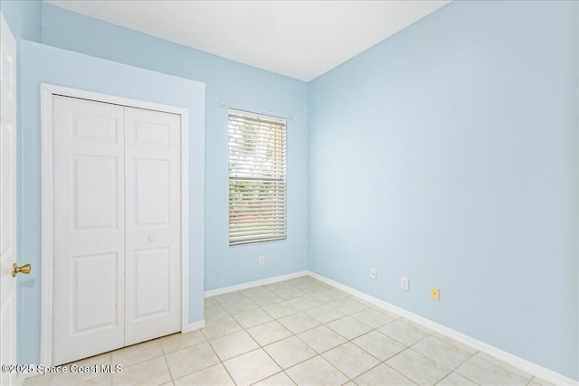 7016 Hammock Trace Dr, Melbourne, FL 32940 - unfurnished bedroom with a closet, baseboards, and light tile patterned floors