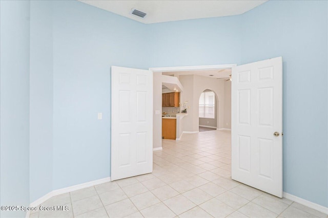 7016 Hammock Trace Dr, Melbourne, FL 32940 - spare room featuring arched walkways, light tile patterned floors, baseboards, and ceiling fan