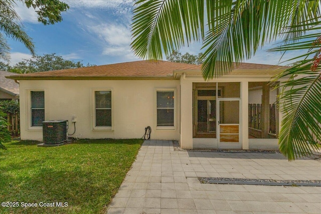7016 Hammock Trace Dr, Melbourne, FL 32940 - property entrance with central AC unit, stucco siding, a lawn, and roof with shingles
