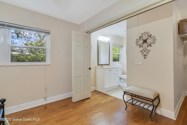 1501 Oranole Rd, Maitland, FL 32751 - bedroom with light wood-style floors, baseboards, and ensuite bath