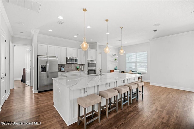 6910 Hundred Acre Dr, Cocoa, FL 32927 - kitchen with a large island with sink, dark wood finished floors, a kitchen breakfast bar, and stainless steel appliances