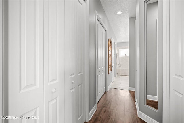 6910 Hundred Acre Dr, Cocoa, FL 32927 - hall featuring dark wood-style flooring, a textured ceiling, recessed lighting, and baseboards
