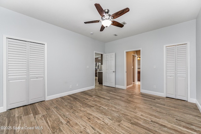 1534 Knoll Ridge Dr, Melbourne, FL 32940 - unfurnished bedroom with visible vents, light wood-style floors, baseboards, two closets, and ceiling fan