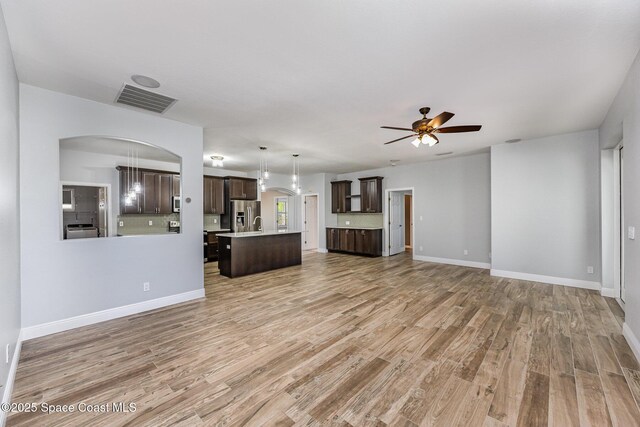 1534 Knoll Ridge Dr, Melbourne, FL 32940 - unfurnished living room with light wood finished floors, visible vents, a ceiling fan, arched walkways, and baseboards