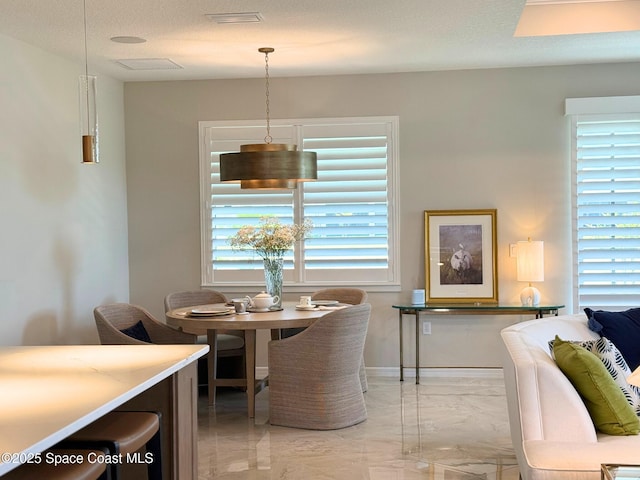 dining room featuring visible vents, baseboards, and marble finish floor