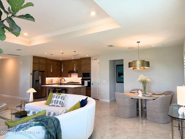 living room with visible vents, baseboards, a tray ceiling, and recessed lighting