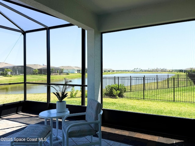 sunroom featuring a water view
