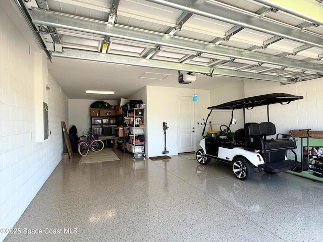 garage with concrete block wall and a garage door opener