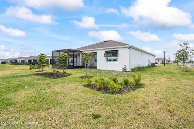 8811 Stormy Sky Ct, Melbourne, FL 32940 - back of property featuring a lawn, stucco siding, and glass enclosure