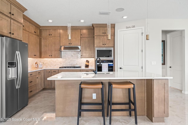 8811 Stormy Sky Ct, Melbourne, FL 32940 - kitchen with stainless steel fridge, light marble finish floors, under cabinet range hood, tasteful backsplash, and light countertops